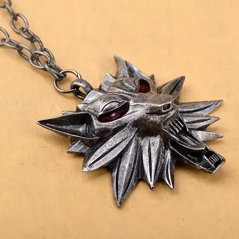 Detaliu pandantiv Witcher Wild Hunt Detaliu apropiat cu medalion The Witcher, material rezistent și bine lucrat